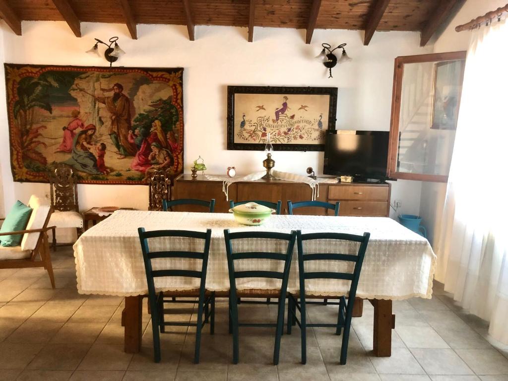 a kitchen with a table with chairs and a painting on the wall at Agrampeli in Limenaria