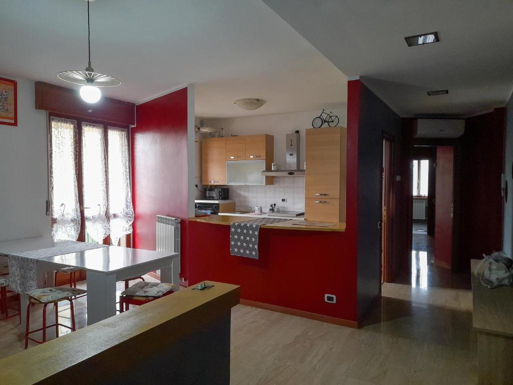 uma cozinha com paredes vermelhas e uma mesa num quarto em BIKE HOUSE 2 "evo" em Seriate