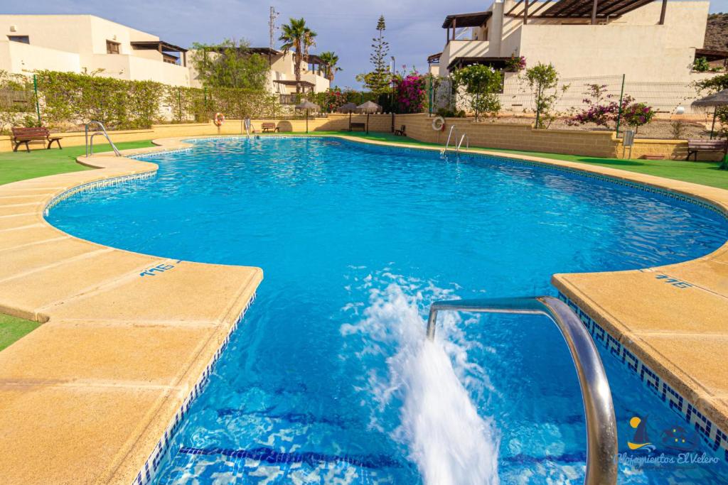 a swimming pool with blue water in a building at El Velero Piscina top y tranquilidad a 450m playa in San José