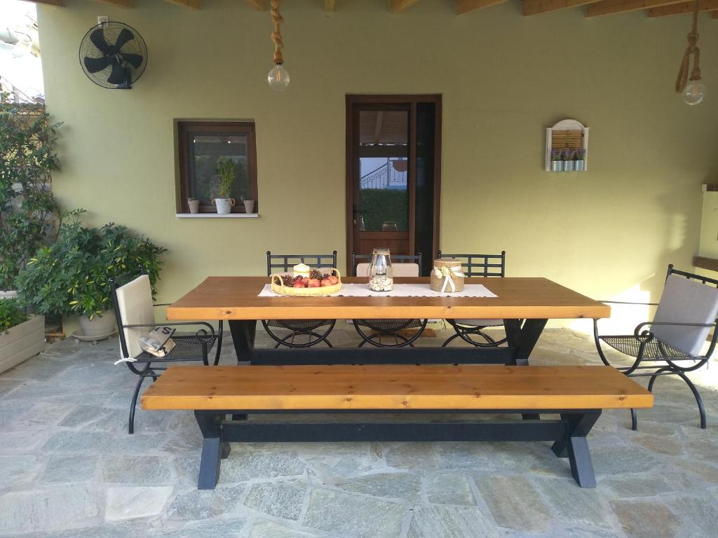 une table en bois et des bancs dans un patio dans l'établissement The family's house, à Tríkala