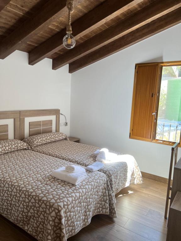 1 dormitorio con 2 camas y ventana en PENSION ORUEIRO VILASERIO, en Negreira