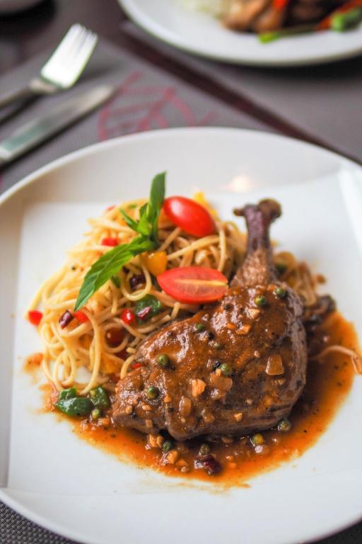 a white plate of food with noodles and meat at FuramaXclusive Sukhumvit in Bangkok