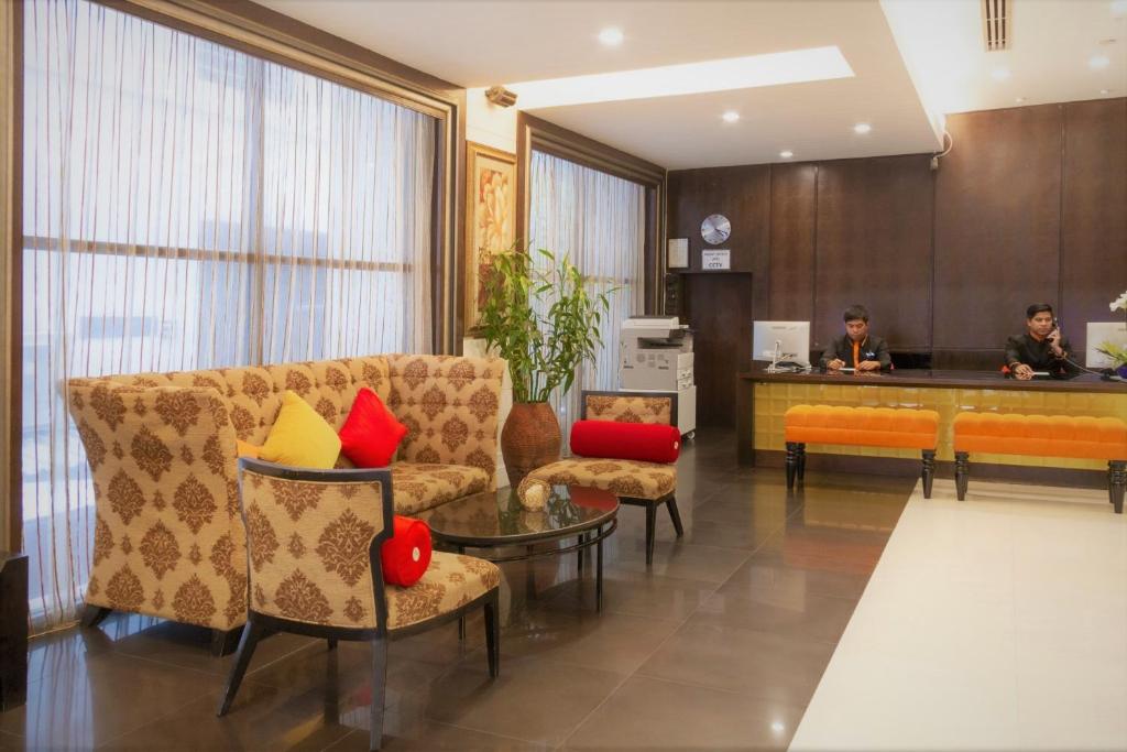 a lobby with a couch and chairs and a counter at FuramaXclusive Sukhumvit in Bangkok
