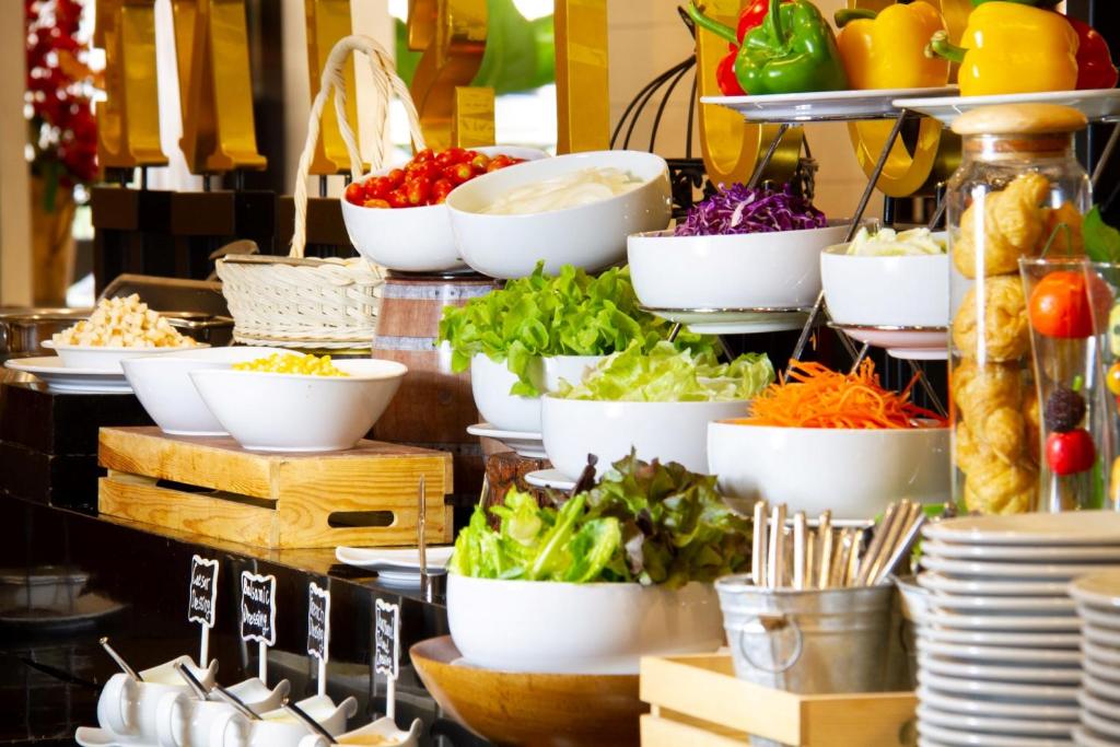 a display of vegetables in white bowls on a table at FuramaXclusive Sukhumvit in Bangkok
