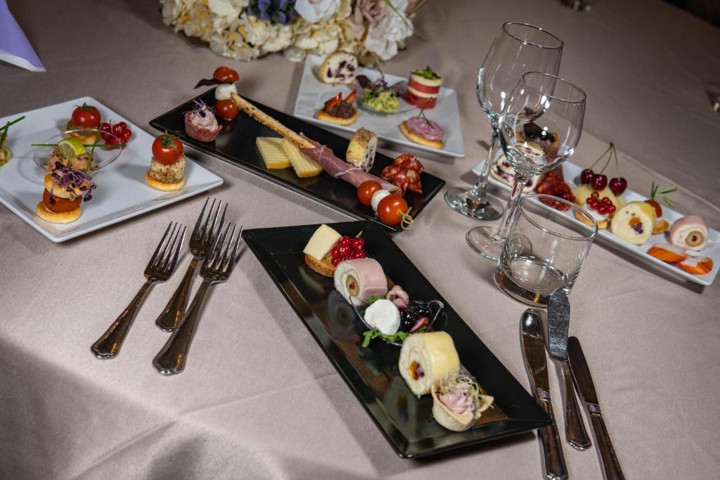 a table topped with plates of food and wine glasses at Hotel Select in Sibiu
