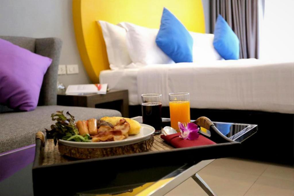 a tray with a plate of food on a table in a hotel room at FuramaXclusive Sukhumvit in Bangkok