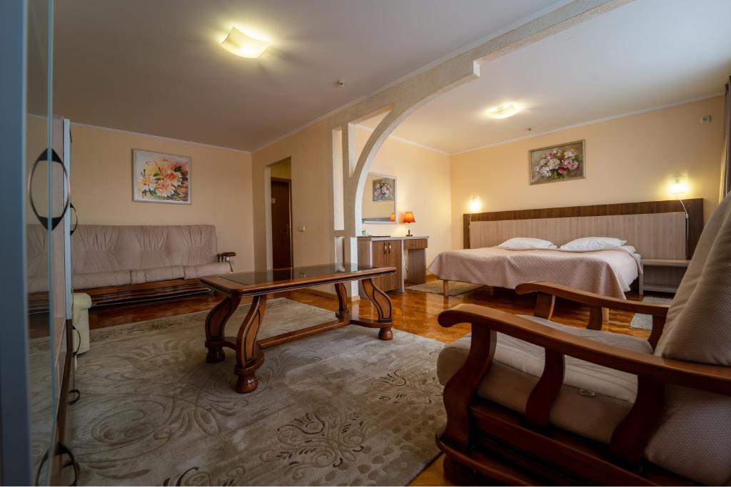 テルノーピリにあるHotel Halychynaのベッドとテーブルが備わるホテルルームです。