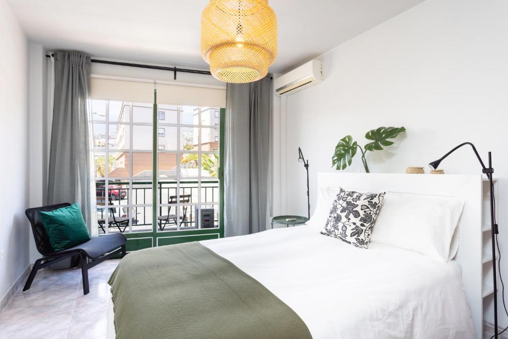 una camera con letto e sedia e un balcone di Home2Book Stylish Apartment Caletillas a Candelaria