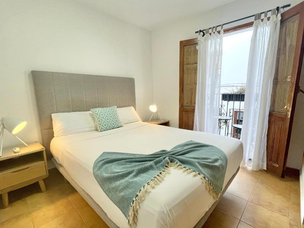 Un dormitorio con una cama con una manta verde encima. en Casa Elizabeth, en Altea