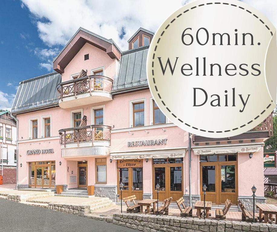 a pink building with a sign that reads omn wellness daily at Wellness Hotel Grand in Špindlerův Mlýn