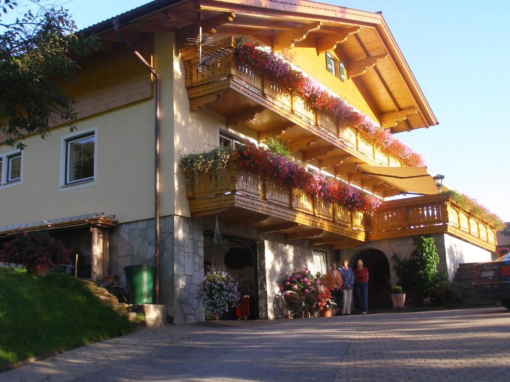 ein Gebäude mit einem Balkon mit Blumen darauf in der Unterkunft Haus Gschwendtner in Pfarrwerfen