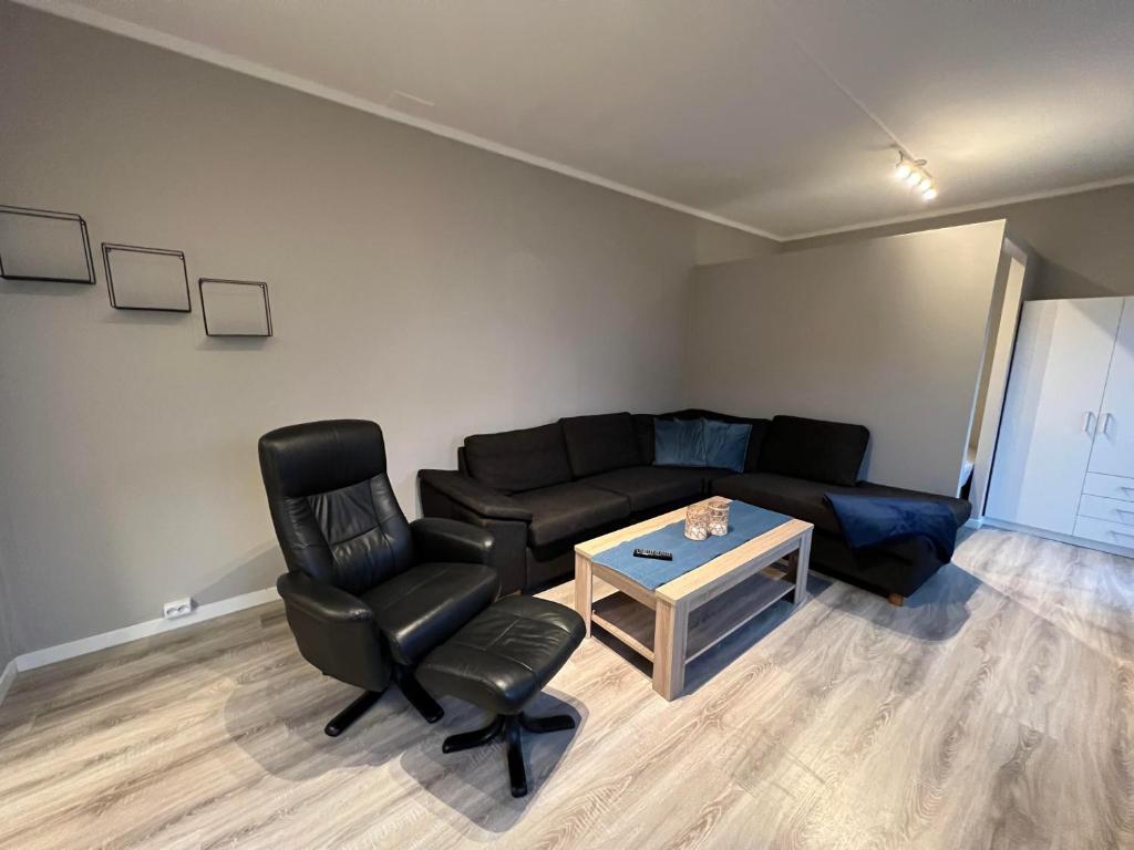 sala de estar con sofá, silla y mesa en Notodden Sentrum Apartment NO 7, en Notodden
