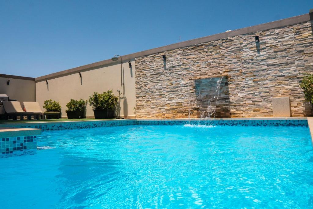 una grande piscina di fronte a un edificio di St. Peter's Pool Holiday Apartment a Marsaxlokk