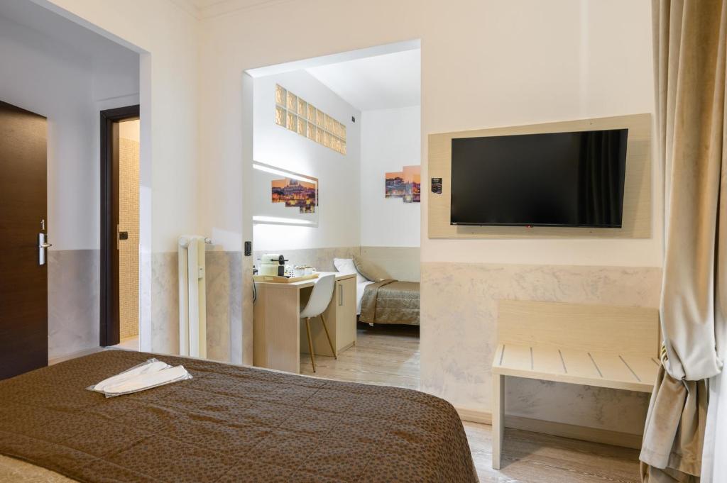 Cola Di Rienzo Suite Guest House في روما: غرفة نوم بسرير وتلفزيون على جدار