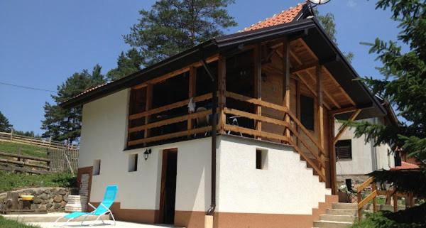 ein kleines Haus mit einem Dach und einem blauen Stuhl in der Unterkunft Vikendica Boki i Maki in Divčibare