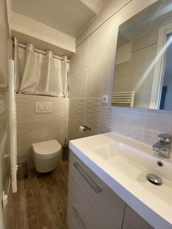 łazienka z białą umywalką i toaletą w obiekcie La Clé Maison de ville, Clim, WiFi à La Bayore w Hyères