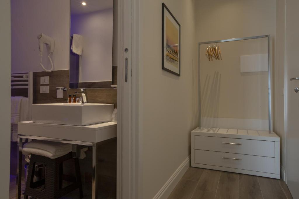 a bathroom with a sink and a mirror at Luxmarì Hotel & Spa in Castellammare del Golfo