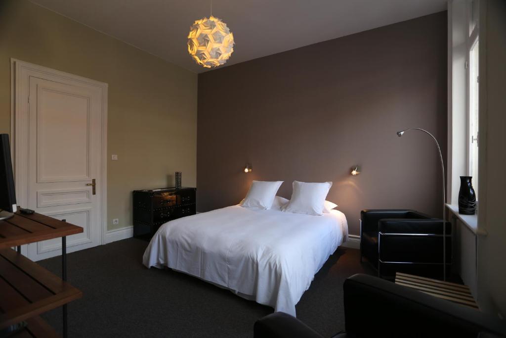 a bedroom with a white bed and a window at B&B Le Cercle De Malines in Calais