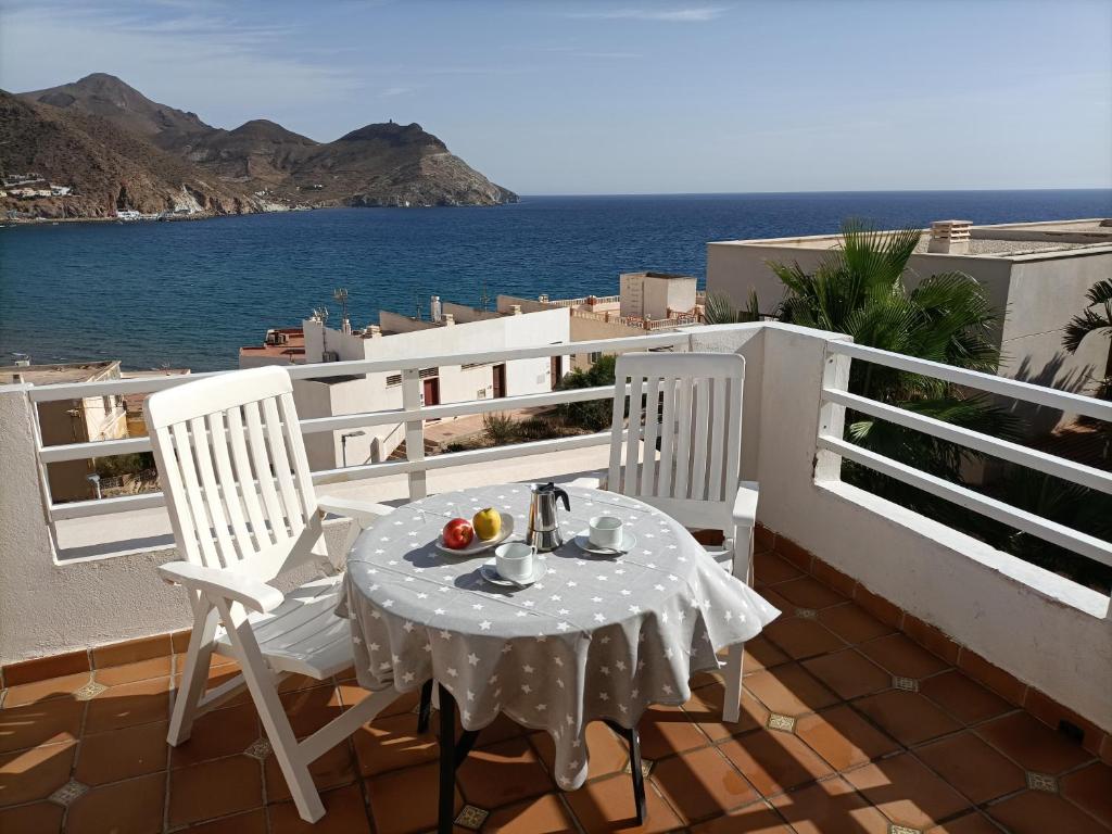 stół i krzesła na balkonie z widokiem na ocean w obiekcie Apartahotel Vistamar San José w mieście San José