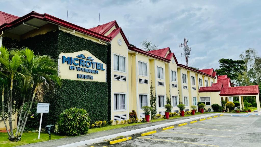 a building with a sign on the side of it at Microtel by Wyndham Tarlac in Tarlac