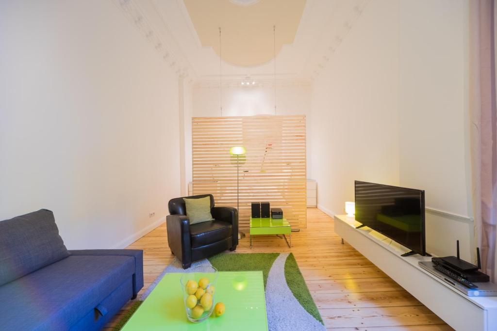 a living room with a blue couch and a television at Urban Pistazie Kreuzberg in Berlin