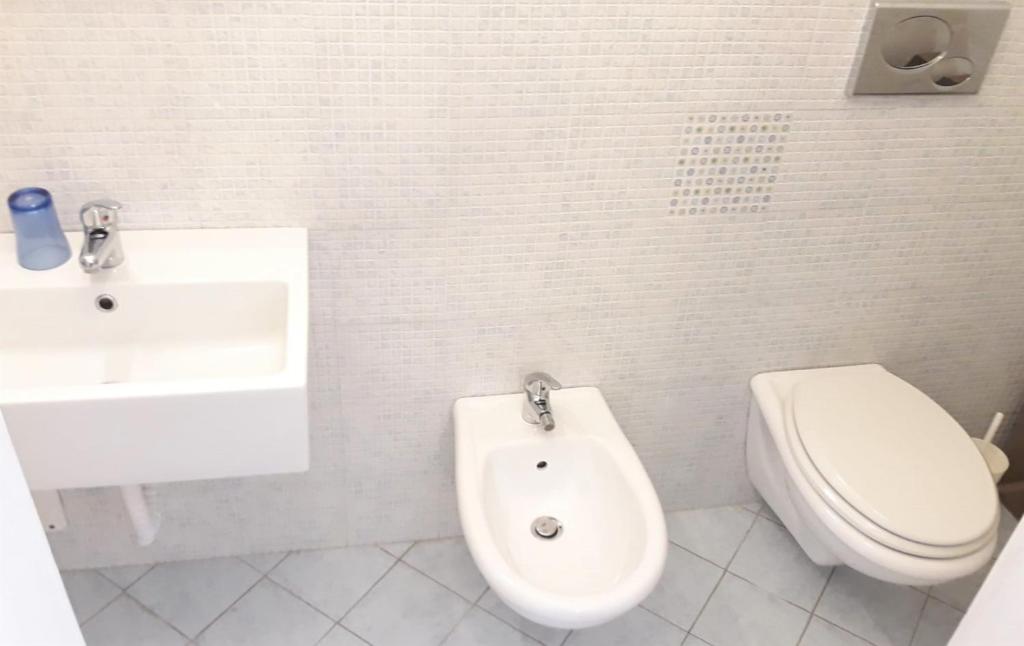 a white bathroom with a toilet and a sink at Bed & Breakfast Porta d'Oriente in Brindisi