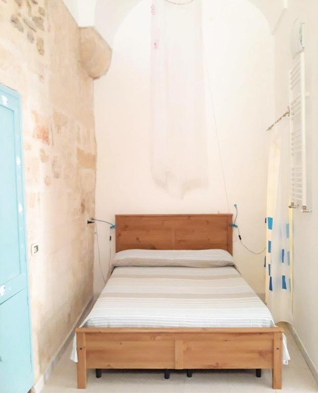 a bedroom with a wooden bed in a room at Bed & Breakfast Porta d'Oriente in Brindisi