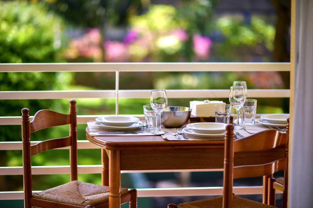 a wooden table with plates and glasses on a porch at Lido Gardens Funchal in Funchal