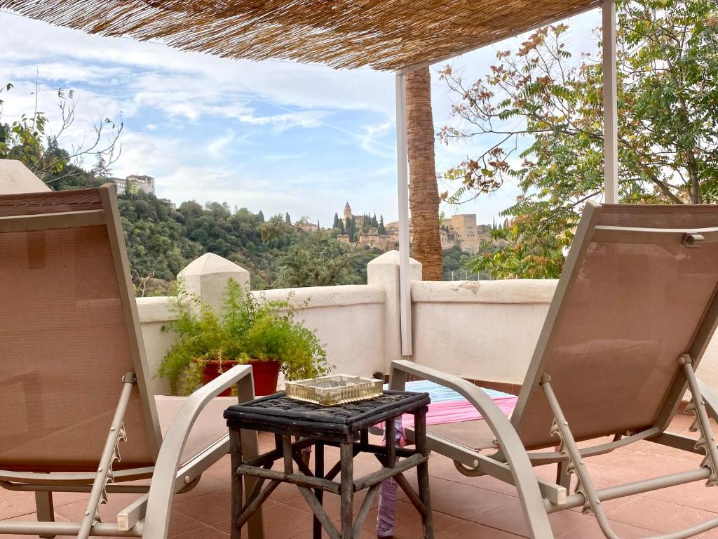 eine Terrasse mit 2 Stühlen und einem Tisch auf dem Balkon in der Unterkunft Cueva con vistas a la Alhambra in Granada