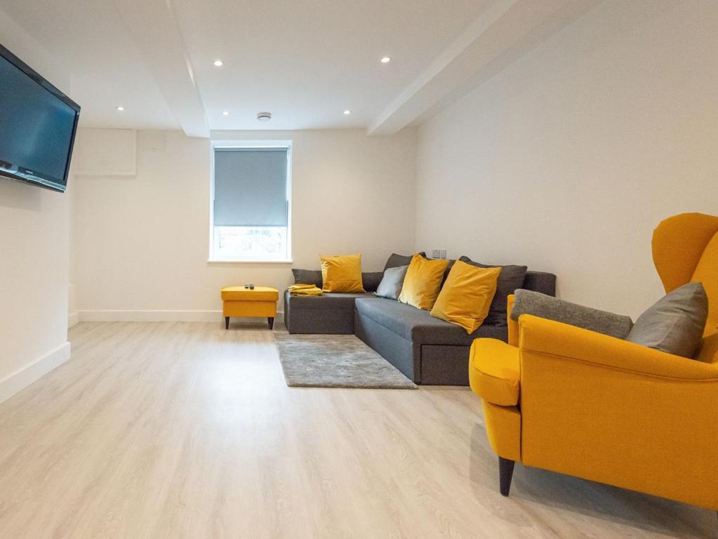 a living room with a couch and yellow chairs at The Suffolk-uk41441 in Brandon