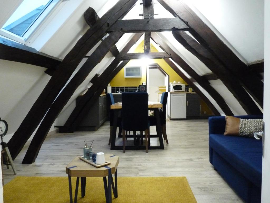 a living room with a blue couch and a table at Gîte d’Eros in Saint-Valery-sur-Somme