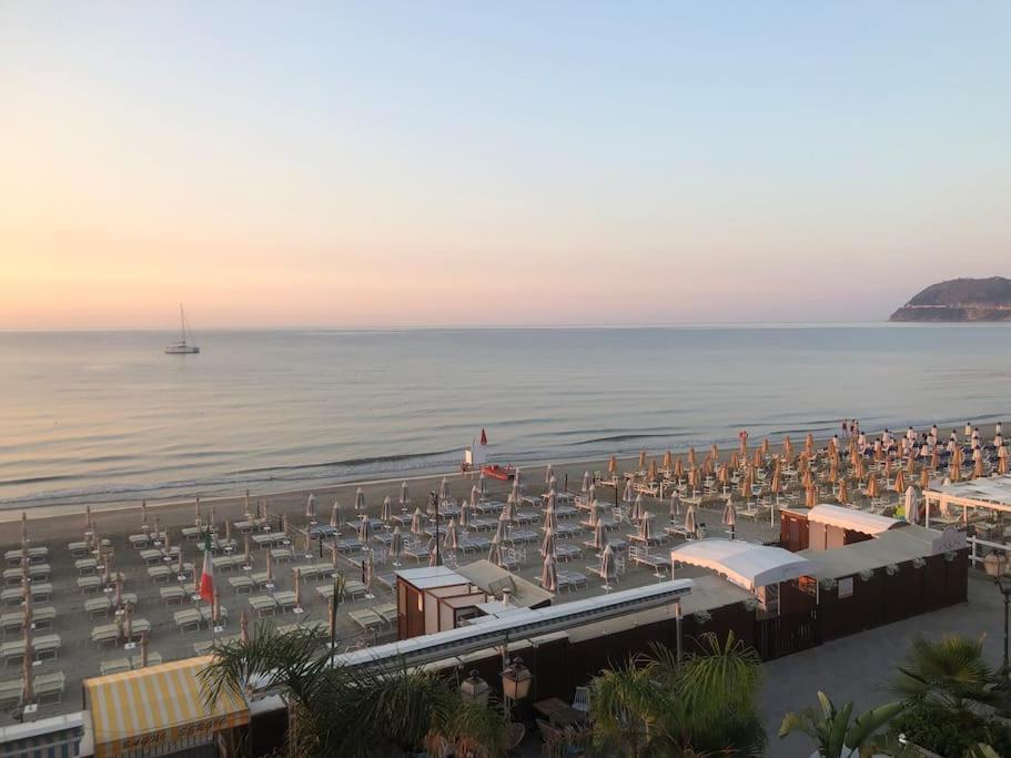 plaża z kilkoma krzesłami i oceanem w obiekcie Budello di Alassio, ampio appartamento con box w Alassio