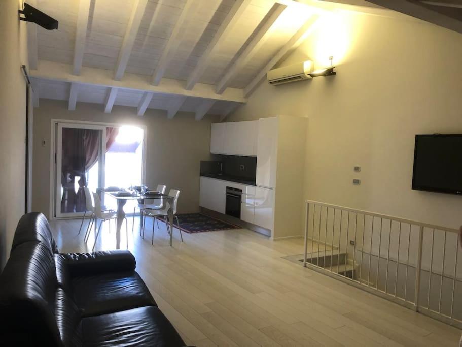 salon z czarną skórzaną kanapą i stołem w obiekcie Budello di Alassio, ampio appartamento con box w Alassio