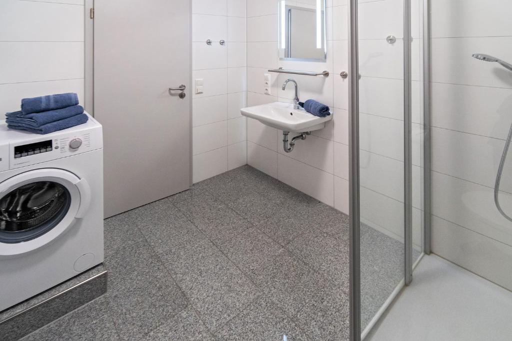 a bathroom with a washing machine and a sink at Ferienhaus Caskade in Bensersiel