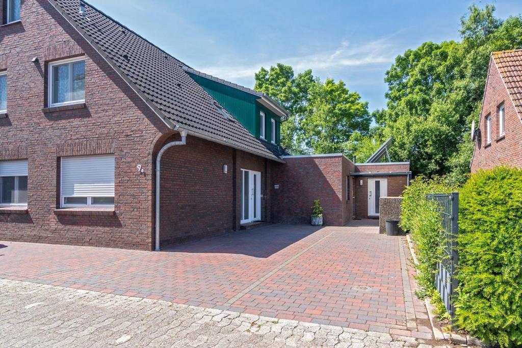 a brick house with a brick driveway at Ferienwohnung Charisma in Bensersiel