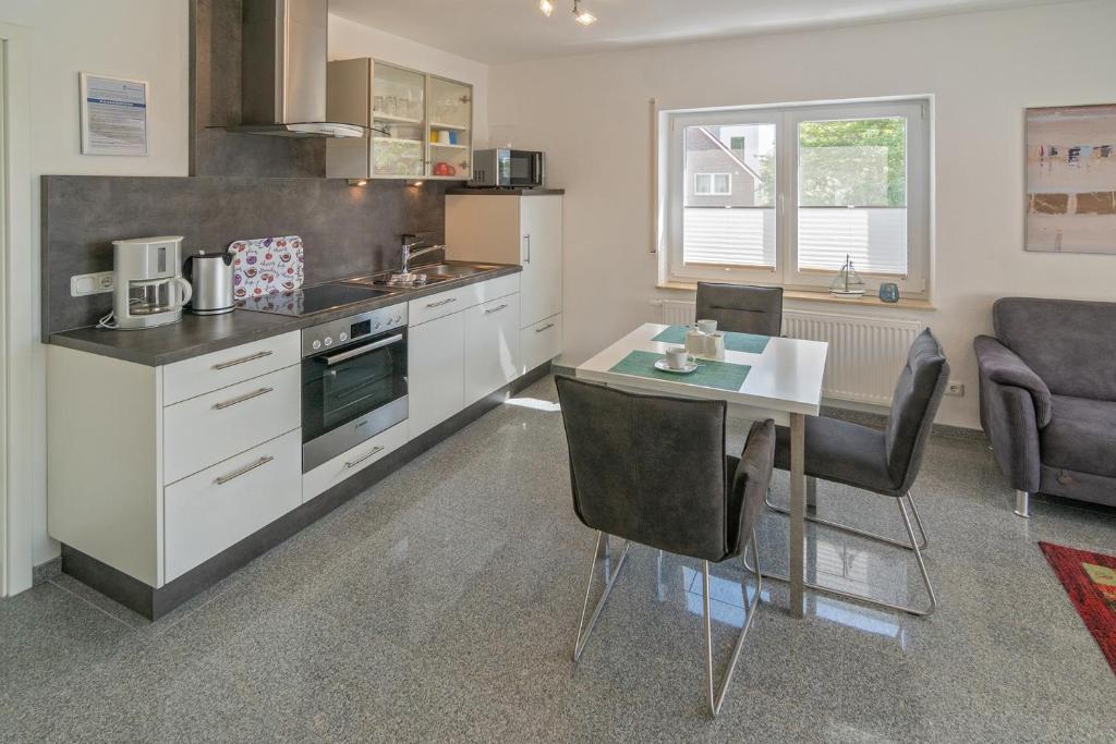 a kitchen with a table and a dining room at Ferienwohnung Bel Air in Bensersiel