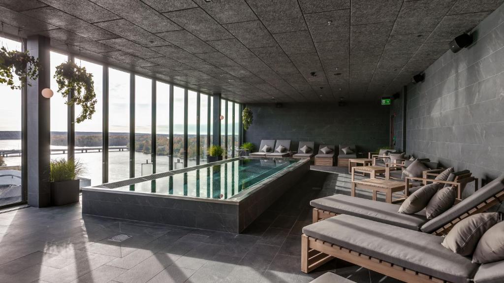 vestíbulo con piscina, sillas y ventanas en Clarion Hotel Umeå en Umeå