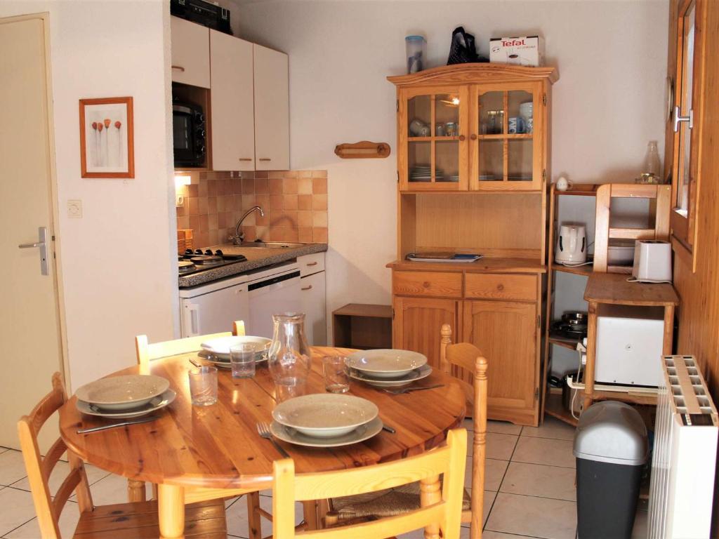 une cuisine avec une table en bois et des plaques de cuisson. dans l'établissement Appartement 2 Pièces Coin Montagne, Terrasse Sud, Parking Privé, Proche Centre et Pistes à Vars Les Claux - FR-1-330B-64, à Vars