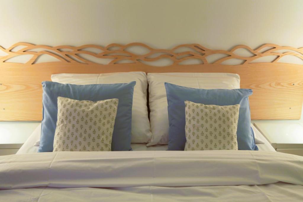 a bed with blue pillows and a wooden headboard at Apartamenty Doliny in Szczyrk