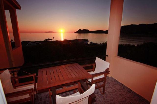 uma varanda com vista para o mar ao pôr-do-sol em Akrogiali Apartments em Agios Ioannis Kaspaka