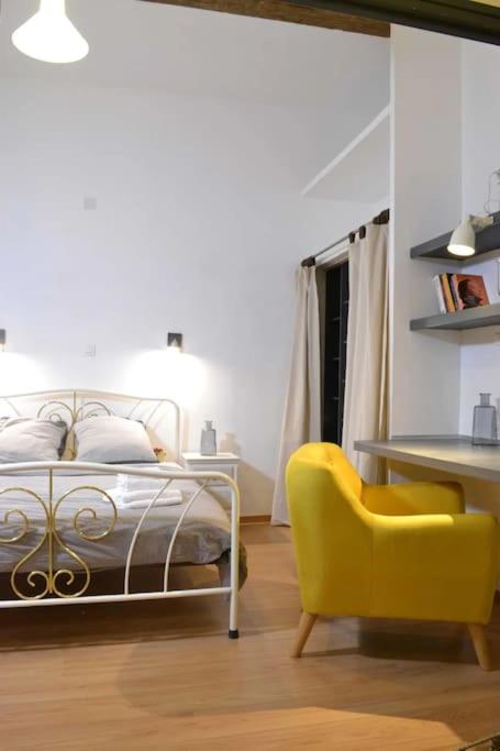 - une chambre avec un lit et une chaise jaune dans l'établissement Comédie Beau T3 Climatisé Cosy avec 2 Suites, à Montpellier
