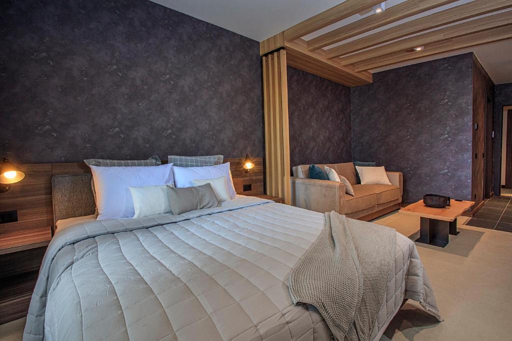 a bedroom with a large bed and a couch at Woodside Kopaonik in Kopaonik