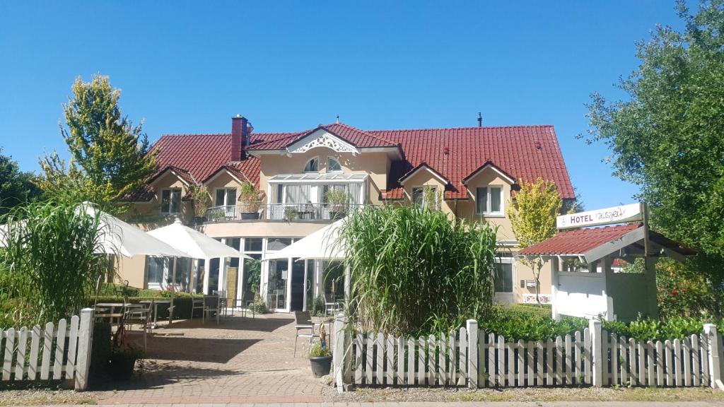 a building with a white fence in front of it at Hotel Garni Auszeit in Boltenhagen