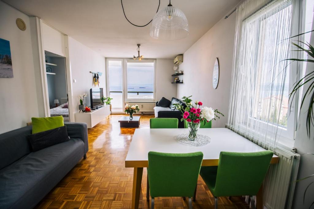 a living room with a table and green chairs at Razgled/The View in Koper