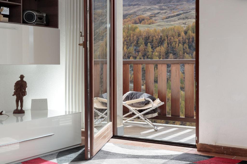 Cette chambre dispose d'un balcon avec vue sur les montagnes. dans l'établissement HelloChalet - Maison Skis Aux Pieds - ski-in with boot warmer and garage, à Breuil-Cervinia