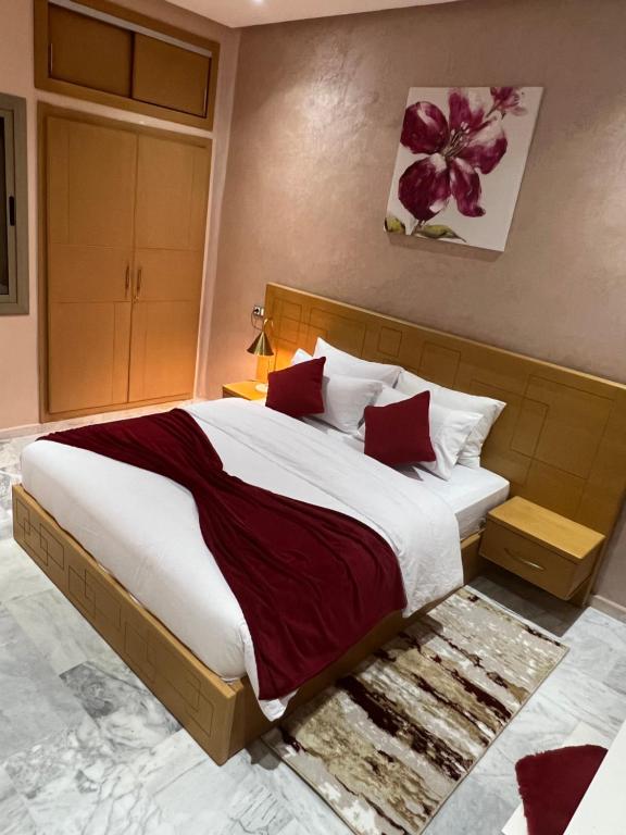 een slaapkamer met een groot bed met rode kussens bij Antonios luxury apartments in Fès