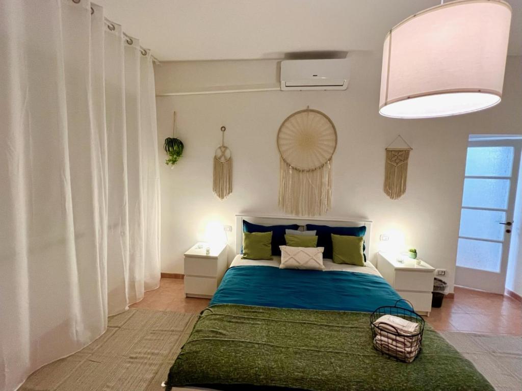 1 dormitorio con 1 cama con sábanas azules y almohadas verdes en Stay in Malpensa en Case Nuove