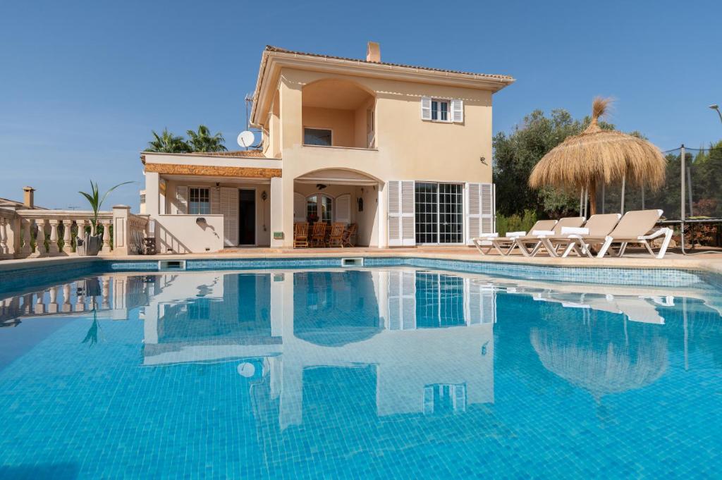 a villa with a swimming pool in front of a house at Villa Sayana in Palma de Mallorca
