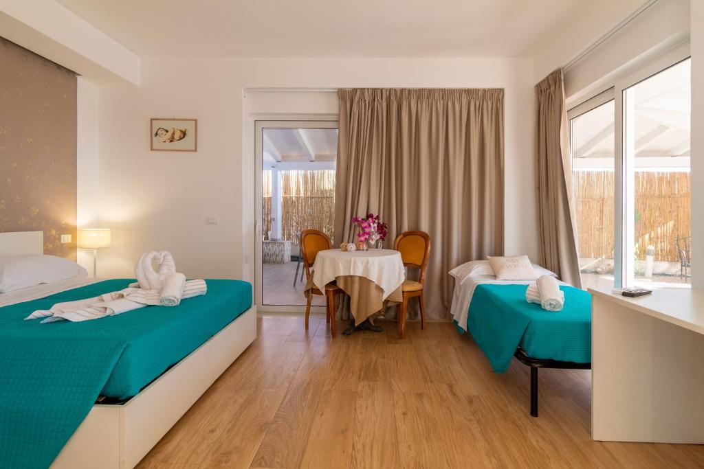 pokój hotelowy z 2 łóżkami i stołem w obiekcie Saija Apartment w mieście Pozzallo