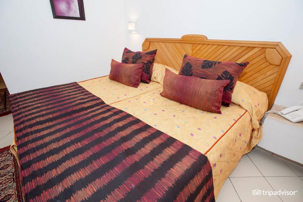 a bedroom with a large bed with pillows on it at Hotel Golf Residence in Hammam Sousse